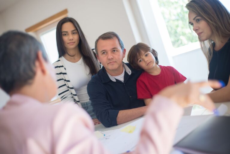a family of four seeks advice from a professional during an indoor consultation in a bright room.