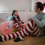 father and daughter enjoying quality time indoors in striped pajamas, family joy and togetherness.